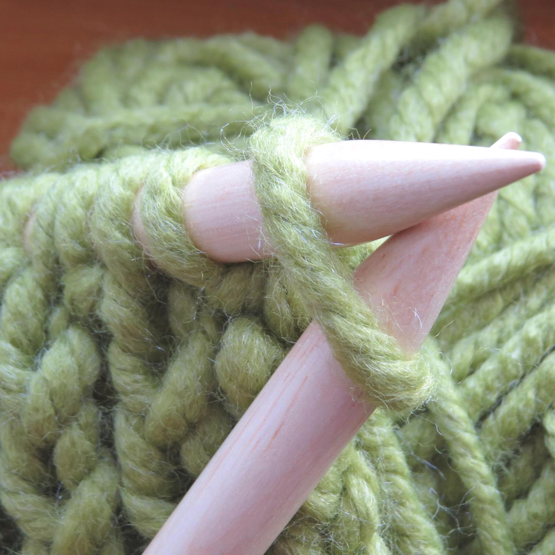 Intro to Knitting: Wooden knitting needles with wooly green yarn